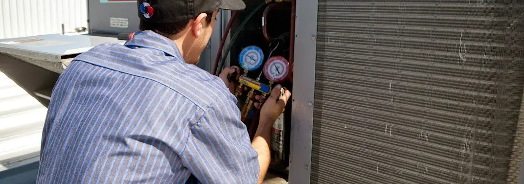 HVAC technician servicing a condenser unit in Ballenger Creek